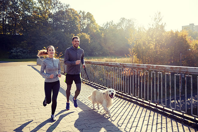 Happy Couple Walking Their Dog