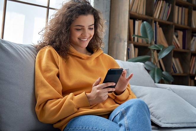 Woman Looking at Her Cell Phone on a Couch
